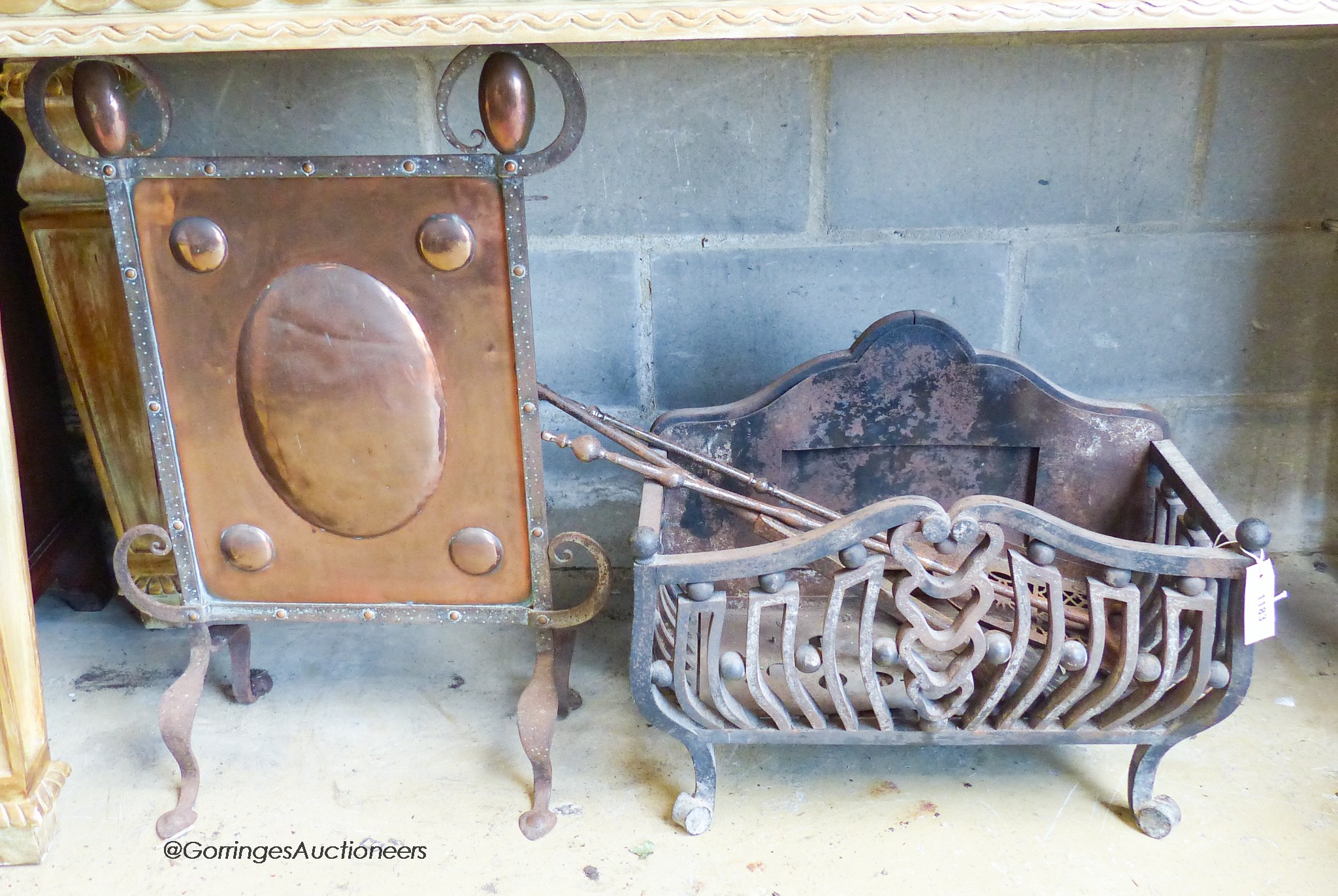 A heavy wrought iron fire basket, width 55cm, depth 28cm, height 46cm together with a set of three fire irons and an Art Nouveau hammered copper and wrought iron fire screen (5)